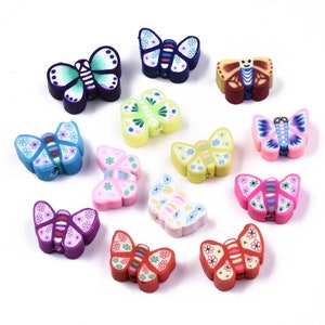 May include: A selection of colourful butterfly-shaped beads. The beads feature various designs, including floral patterns and solid colours like blue, pink, and green. Each bead has a hole for stringing.