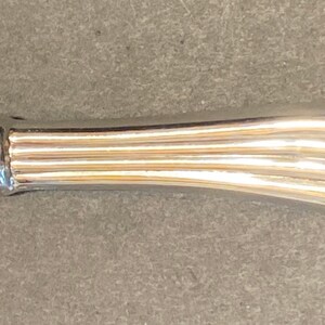 May include: A silver makeup brush with a brown bristle brush head.