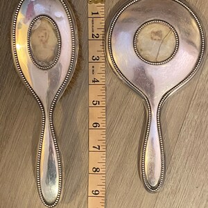 Puede incluir: Dos espejos de mano plateados con bordes perlados. Cada espejo tiene un peque&ntilde;o espejo ovalado en el centro. Los espejos miden 25,4 cm de largo.