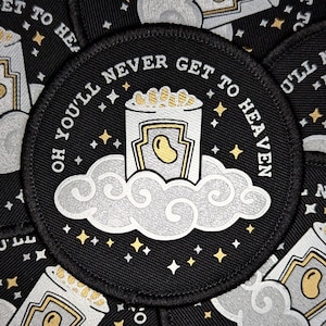 May include: A black round patch with white text that reads "Oh you'll never get to heaven". The text is surrounded by a white cloud with a silver outline. A silver can with a yellow bean inside is on top of the cloud. The background is black with gold stars.