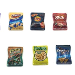 May include: A collection of miniature snack packets, including Takis, Fritos, Lays, Cheetos, Funyuns, and Doritos. The packets are brightly coloured, with text and graphics identifying the brands and flavours. The snacks are arranged on a white background.