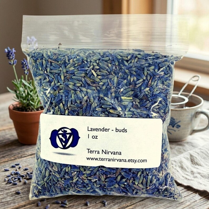 Peut inclure: Un sac en plastique transparent rempli de boutons de lavande s&eacute;ch&eacute;s. L'&eacute;tiquette indique "Lavender - buds 1 oz" avec un logo et une adresse de site web. Une petite plante de lavande en pot et une tasse &agrave; th&eacute; sont en arri&egrave;re-plan.