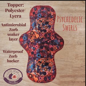 May include: A reusable menstrual pad with a vibrant psychedelic swirl pattern in shades of red, orange, blue, and purple. The pad features the text "PSYCHEDELIC SWIRLS" and is made with a polyester/lycra topper, antimicrobial zorb soaker layer, and waterproof zorb backer.