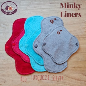 May include: Minky liners in red, pink, turquoise, and silver, with snap closures. The silver liners are 6 and 9 inches long. The image includes the text "Minky Liners" and "Red Turquoise Silver". The Fig Tree Studio logo is in the upper left corner.