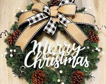 May include: A Christmas wreath with a black and white buffalo plaid bow, pine branches, pine cones, and a white wooden sign that says "Merry Christmas".
