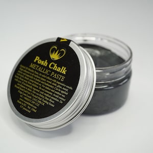 May include: A silver jar with a black lid containing a black metallic paste. The lid has a label that reads "Posh Chalk Metallic Paste" and includes instructions for use.