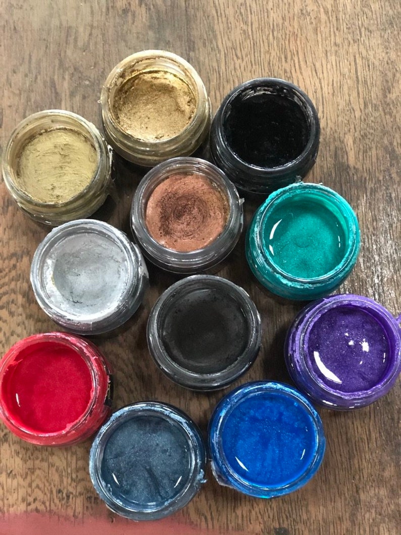 May include: Ten small round jars of metallic paint in various colours, including gold, silver, black, red, blue, green, and purple.
