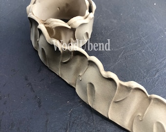 May include: A beige, decorative, flexible molding with a repeating pattern of leaves. The molding is rolled up and the text "WoodUbend" is visible on the side.