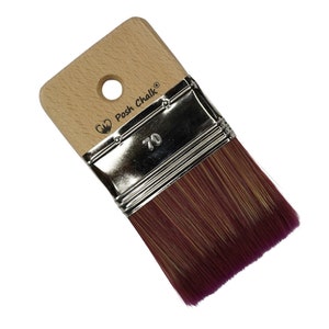 May include: A wooden-handled paint brush with a silver ferrule and purple bristles. The handle has a hole for hanging and the text "Posh Chalk®" printed on it. The ferrule has the number "70" printed on it.