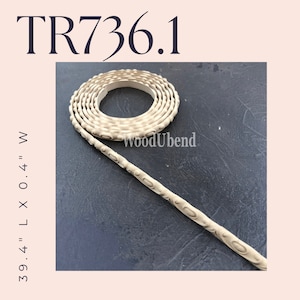 May include: A roll of beige wood trim with a decorative pattern. The trim is 39.4 inches long and 0.4 inches wide. The trim is labelled "TR736.1" and "woodUbend".