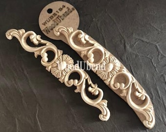 May include: Two decorative wooden appliques with floral and scroll designs. One is curved and the other is a smaller, angled piece. The appliques are a light beige color and have a tag that reads "WUB2154 WoodUbend."