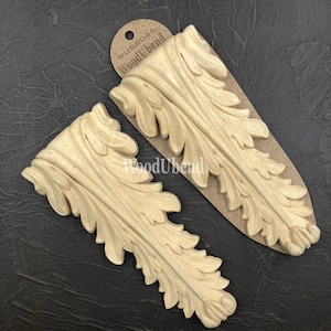 Puede incluir: Dos molduras decorativas de madera beige con un diseño de hojas. Las molduras están etiquetadas "WoodUbend".