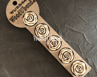 Puede incluir: Un conjunto de cinco adornos de madera en forma de rosa en una tarjeta de exhibición de madera marrón. La tarjeta tiene el texto "WUB344 WoodUbend" impreso en ella.
