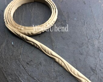 Puede incluir: Una moldura de madera con un diseño ondulado. La moldura está enrollada y lista para ser utilizada con fines decorativos.