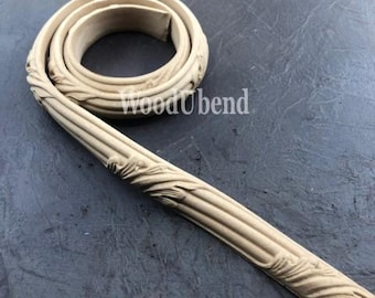 May include: A close-up of a wooden trim molding with a decorative, ornate design. The molding is flexible and can be bent into curves. The molding is unfinished and ready to be painted or stained.