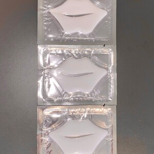 May include: Three individually packaged lip masks in clear plastic pouches. Each pouch contains a white lip-shaped mask.