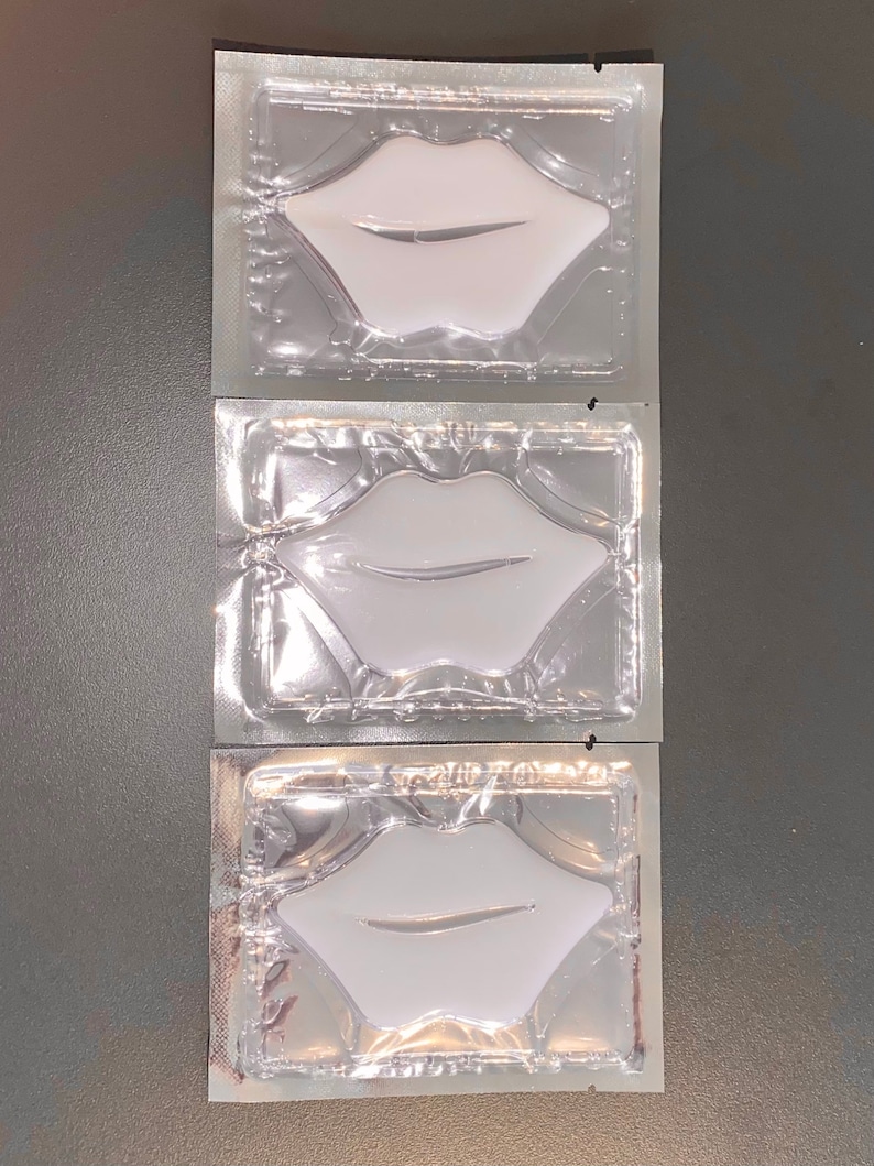 May include: Three individually packaged lip masks in clear plastic pouches. Each pouch contains a white lip-shaped mask.