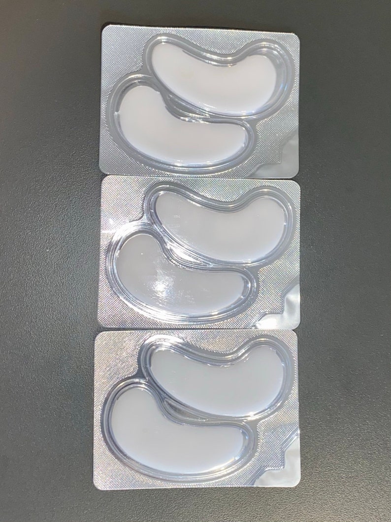 May include: Three individual packages of under-eye patches. Each package contains two crescent-shaped patches in a clear plastic tray.