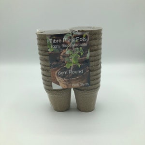 Könnte beinhalten: Eine Packung mit 25 biologisch abbaubaren Pflanzentopf aus Faser, rund, 6 cm. Die Töpfe sind braun und in durchsichtigem Plastik verpackt. Das Etikett lautet "Fibre Plant Pots 100% Biodegradable 6cm Round Pack Qty 25".