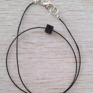 Men’s LAVA Necklace. Delicate shimmering black neck strap with small lava stone and silver closure.