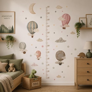 May include: A wall decal height chart featuring hot air balloons, clouds, stars, and a crescent moon. The vertical scale is marked in centimeters from 50 to 160. The design includes various colored balloons in blue, pink, and grey tones.
