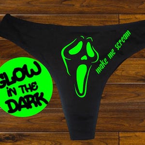 May include: Black underwear with a green glow-in-the-dark graphic of a screaming face and the text "Make me scream".