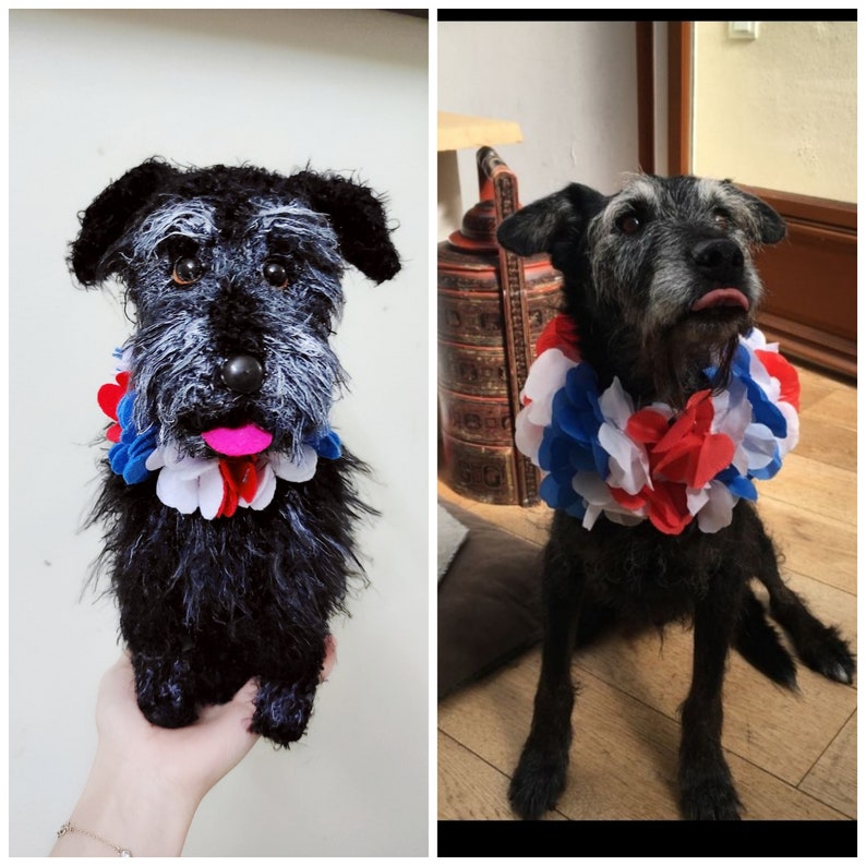 May include: A black and white plush dog toy wearing a red, white, and blue flower garland. The toy is sitting on a person's hand.