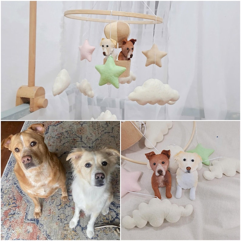 May include: A baby mobile with a hot air balloon, stars, and clouds. The balloon has a dog's face on it. There are two other dogs hanging from the mobile.