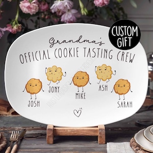 Może przedstawiać: Biała owalna tacka do serwowania z tekstem "Grandma's Official Cookie Tasting Crew" i czterema kreskówkowymi ciasteczkami z nazwami "Josh", "Jony", "Mike" i "Sarah".