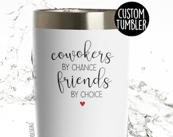 May include: White stainless steel tumbler with a black and white design that says "Coworkers by chance, friends by choice" with a small red heart.
