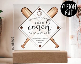 Puede incluir: Una placa de acrílico transparente con un diseño de diamante de béisbol y bates de béisbol cruzados. El texto dice "Un buen entrenador puede cambiar un juego. Un GRAN entrenador PUEDE CAMBIAR UNA VIDA. Gracias por todo, entrenador! NOMBRE DEL EQUIPO AÑO".