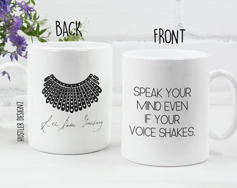 May include: White ceramic mug with a black silhouette of a collar and the text "Speak your mind even if your voice shakes." on the front. The back of the mug has a black silhouette of a collar and the signature "Ruth Bader Ginsburg".