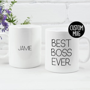 May include: Two white ceramic mugs. One mug has the text "BEST BOSS EVER." printed in black. The other mug has the name "JAMIE" printed in black.