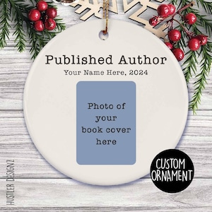 May include: White ceramic Christmas ornament with the text "Published Author" and "Your Name Here, 2024". A blue rectangle with the text "Photo of your book cover here" is in the center of the ornament. The ornament has a gold string for hanging.