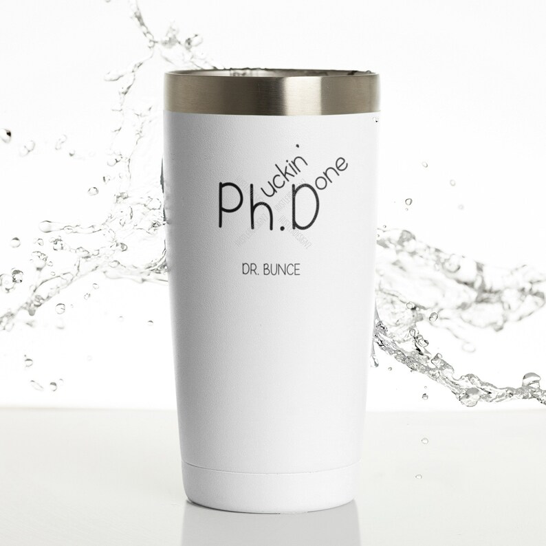 May include: White insulated tumbler with a silver rim. The tumbler features the text "Ph.D fuckin' done" and "DR. BUNCE" in black. The tumbler is designed to keep beverages hot or cold.