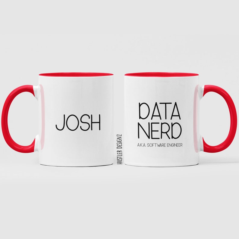 以下が含まれることがあります： 赤い縁取りのある白いコーヒーカップが2つ。1つのカップには「Josh」と書いてあり、もう1つのカップには「Data Nerd AKA Software Engineer」と書いてあります。