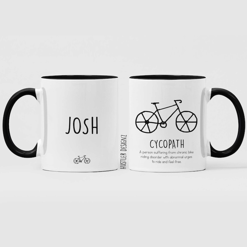 May include: Two white ceramic mugs with black handles and black rims. The mug on the left has the name "JOSH" printed on it and a small bicycle illustration. The mug on the right has a larger bicycle illustration and the word "CYCOPATH" printed below it. The definition of "CYCOPATH" is printed below the word: "A person suffering from chronic bike riding disorder with abnormal urges to ride and feel free."