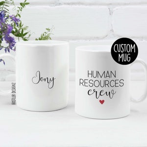 White ceramic mug with the words “Human Resources Crew” and personalized name on the back – ideal gift for HR professionals or team members.