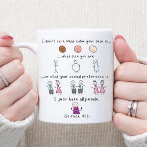 Puede incluir: Taza de cerámica blanca con un diseño negro dibujado a mano y texto. El texto dice: "No me importa el color de tu piel... Qué talla tienes... o cuál es tu preferencia sexual. Simplemente odio a todas las personas. ¡Así que vete a la mierda!"