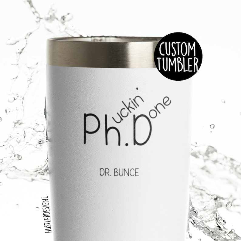 May include: White custom tumbler with a silver rim. The tumbler features the text "Ph.D fuckin' done" in black, with "DR. BUNCE" below. A black circle with "CUSTOM TUMBLER" is on the upper right. The HustlerDesignz logo is on the left.