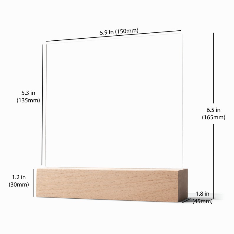 May include: A clear acrylic picture frame with a wooden base. The frame measures 5.9 inches by 6.5 inches and the base is 1.8 inches wide.