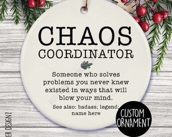 May include: A round, white ceramic ornament with the words "CHAOS COORDINATOR" in black. The ornament has text that reads "Someone who solves problems you never knew existed in ways that will blow your mind." A small black circle says "CUSTOM ORNAMENT."