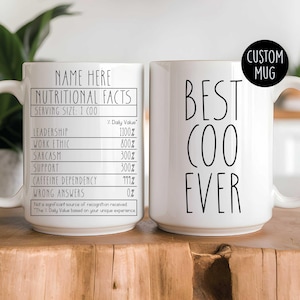 May include: Two white ceramic mugs featuring black text. One mug displays a nutritional facts label with categories like leadership and sarcasm. The other mug features the text BEST COO EVER in a tall, thin font. A black circle says CUSTOM MUG.