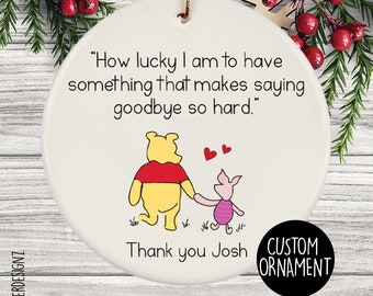 May include: A white ceramic Christmas ornament featuring Winnie the Pooh and Piglet holding hands, with the text "How lucky I am to have something that makes saying goodbye so hard." and "Thank you Josh."