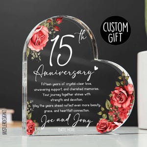 May include: Clear heart-shaped anniversary gift with red roses and the text "15th Anniversary." The gift includes a personalized message and the words "Custom Gift."