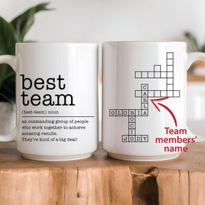 Puede incluir: Taza de cerámica blanca con un diseño en blanco y negro. La taza presenta la palabra "best team" con una definición debajo. El otro lado de la taza tiene un crucigrama con los nombres "Gloria", "Carl", "Jody" y "OCI" rellenos.
