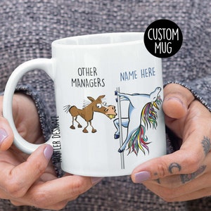 May include: White ceramic mug with a cartoon illustration of a unicorn on a pole and a donkey. The text "Other Managers" is above the donkey and "Name Here" is above the unicorn.