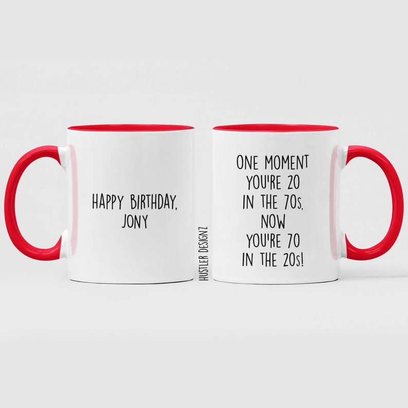 Może przedstawiać: Dwa białe kubki z czerwonymi obw&oacute;dkami i czarnym tekstem. Jeden kubek m&oacute;wi "Happy Birthday, Jony". Drugi kubek m&oacute;wi "Chwila jesteś 20 w latach 70. Teraz masz 70 w latach 20!"