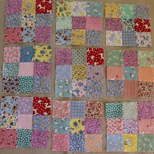 May include: Nine square quilt blocks arranged in a grid, each composed of nine smaller fabric squares. The fabric features a variety of colorful patterns including floral, geometric, and cartoon prints in shades of red, blue, yellow, pink, and green.