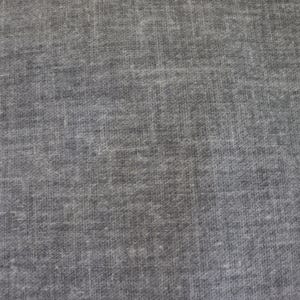 May include: Close-up of a gray fabric with a textured surface. The fabric has a woven appearance with visible threads and a subtle, mottled pattern. The color is a muted, neutral gray.